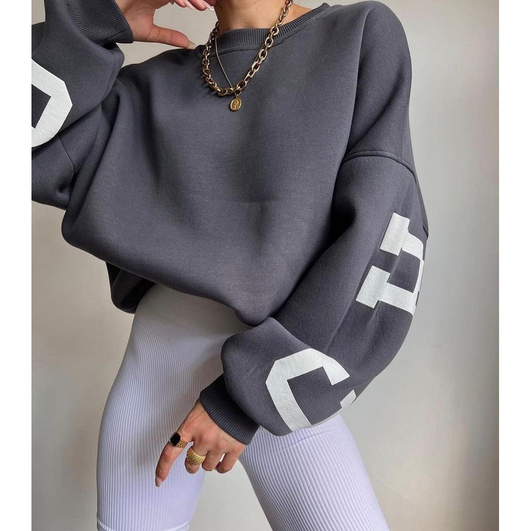 Woman wearing the Priya women's hooded sweater in beige, back view
