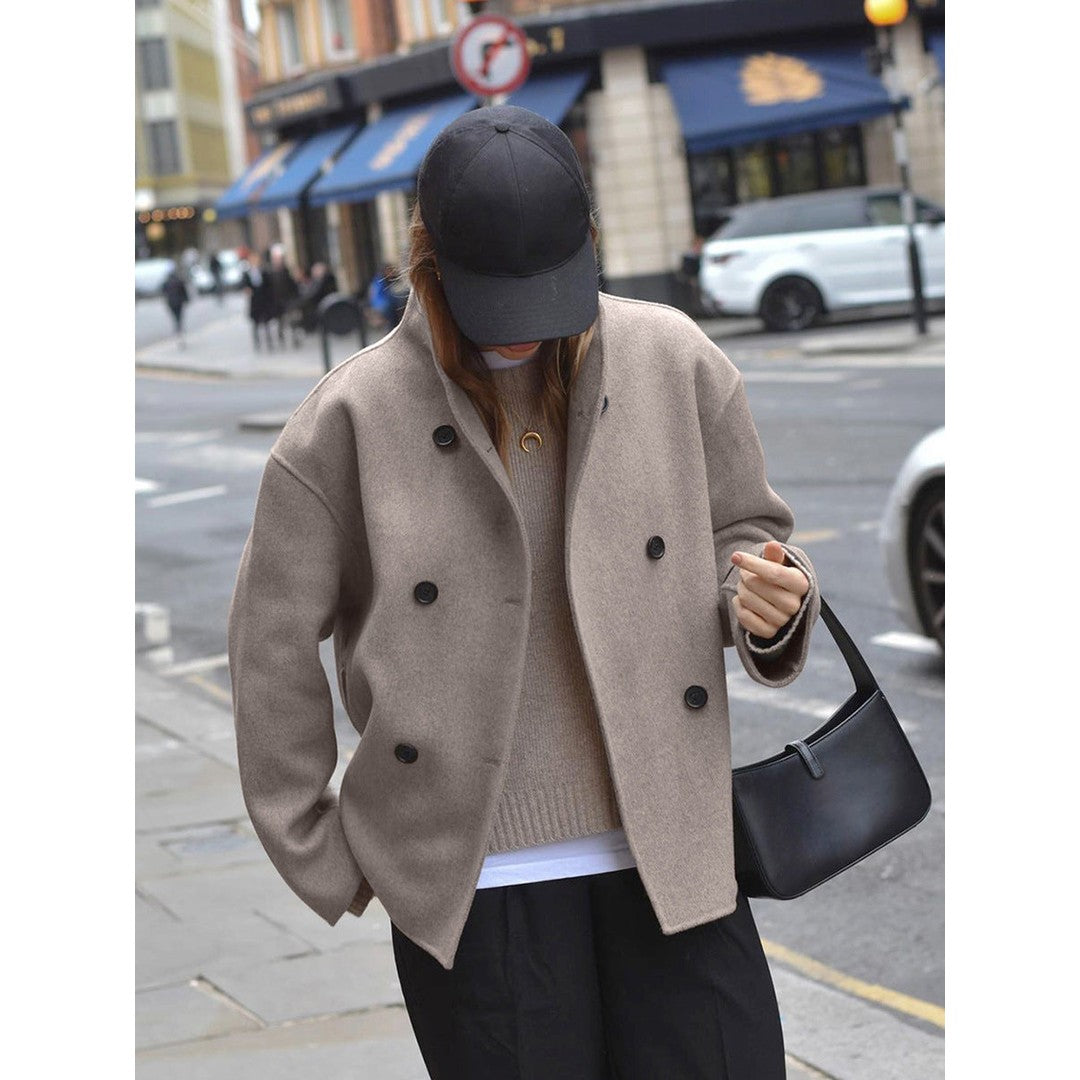 Woman wearing the Wilhelmina women's cropped mock-neck button-up jacket in beige, back view