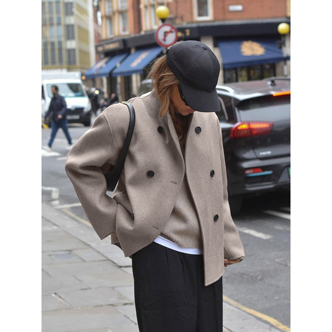 Woman wearing the Wilhelmina women's cropped mock-neck button-up jacket in beige, front view