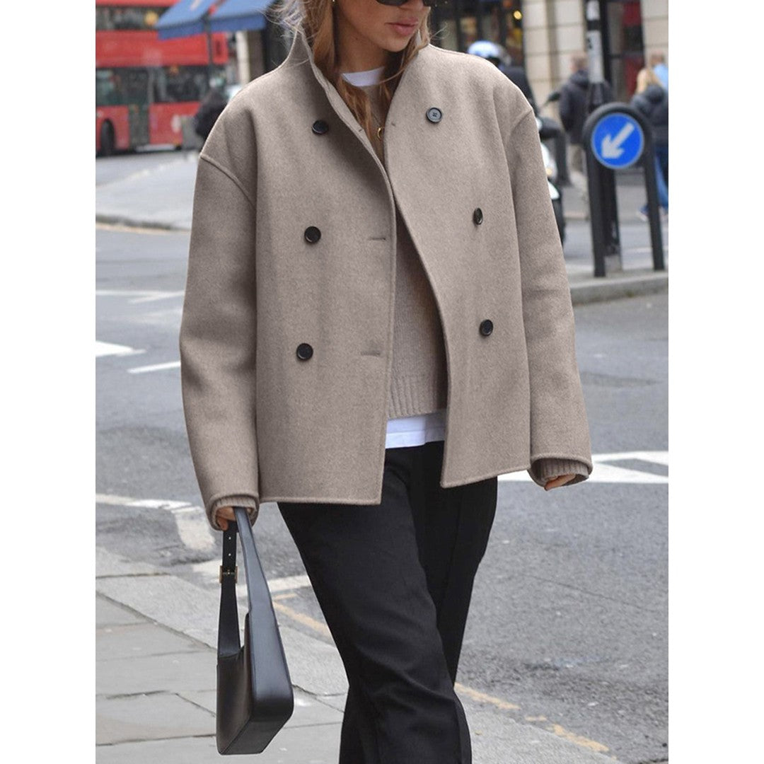Woman wearing the Wilhelmina women's cropped mock-neck button-up jacket in beige, side view