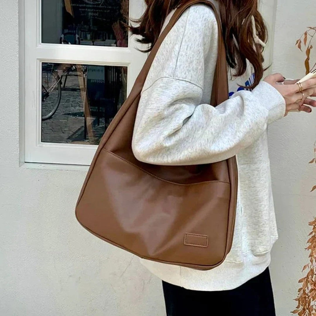 Woman wearing the Zosia women's pocket detail bag, flatlay view